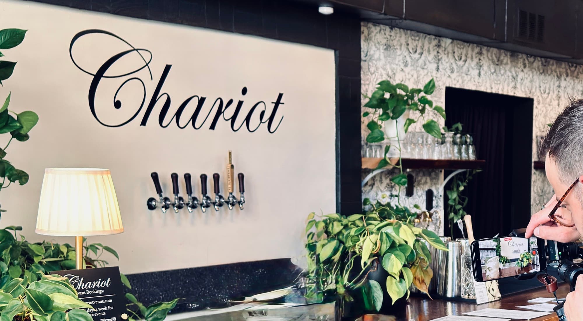 The Chariot mark on display behind the redwood bar.
